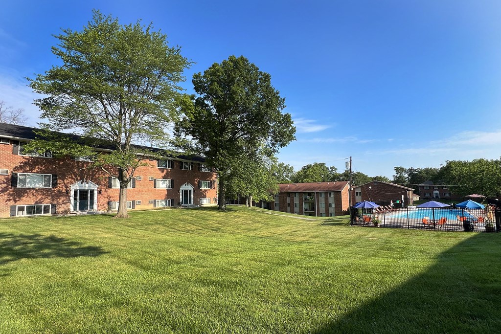 a large yard in front of a brick house with a pool at Sharondale Woods Apartments, Cincinnati