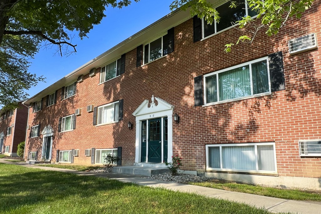 a red brick apartment building with a green door at Sharondale Woods Apartments, Cincinnati, OH
