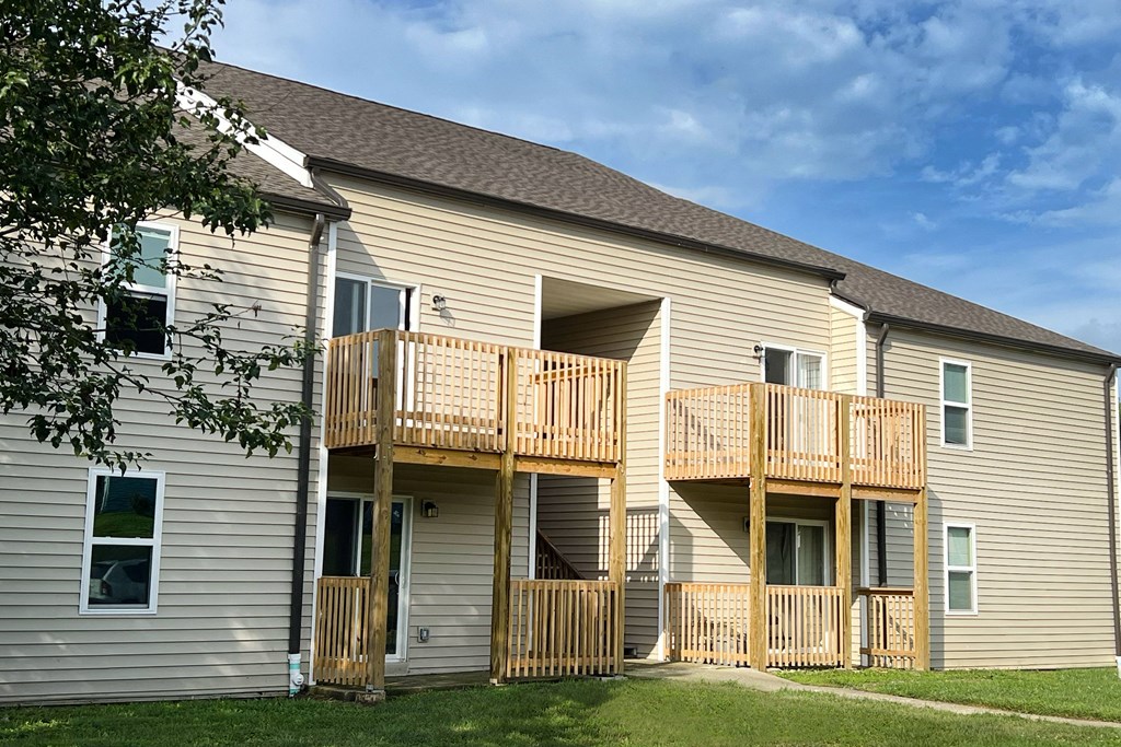 the back of a house with two balconies and a tree at 450 on Keeneland Apartments, Richmond, KY