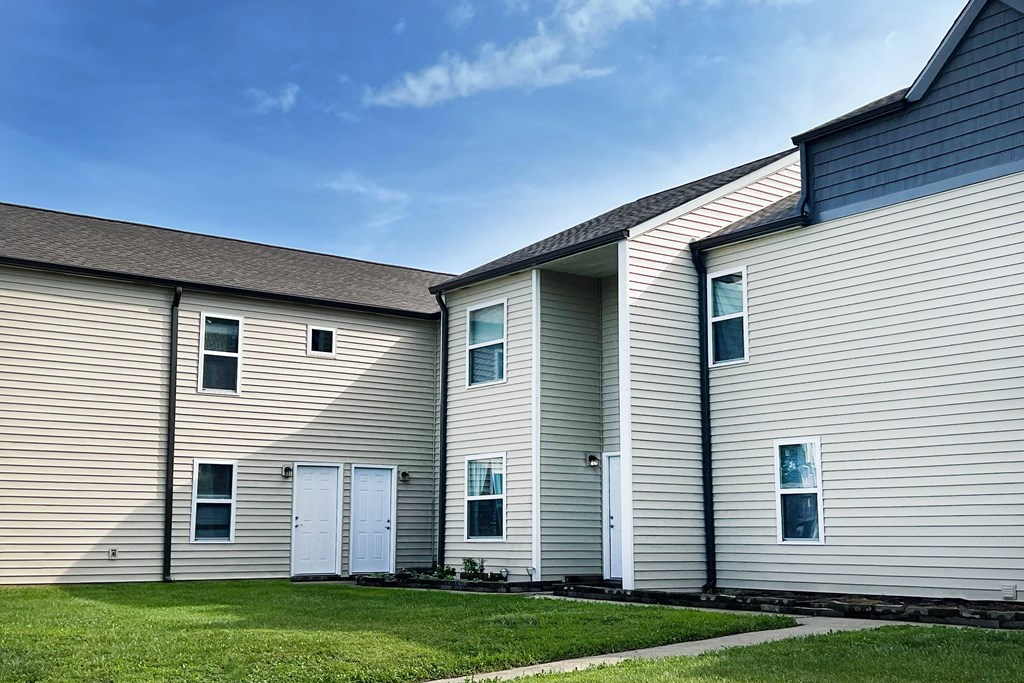 a row of houses with white siding and a grass yard at 450 on Keeneland Apartments, Richmond, KY 40475