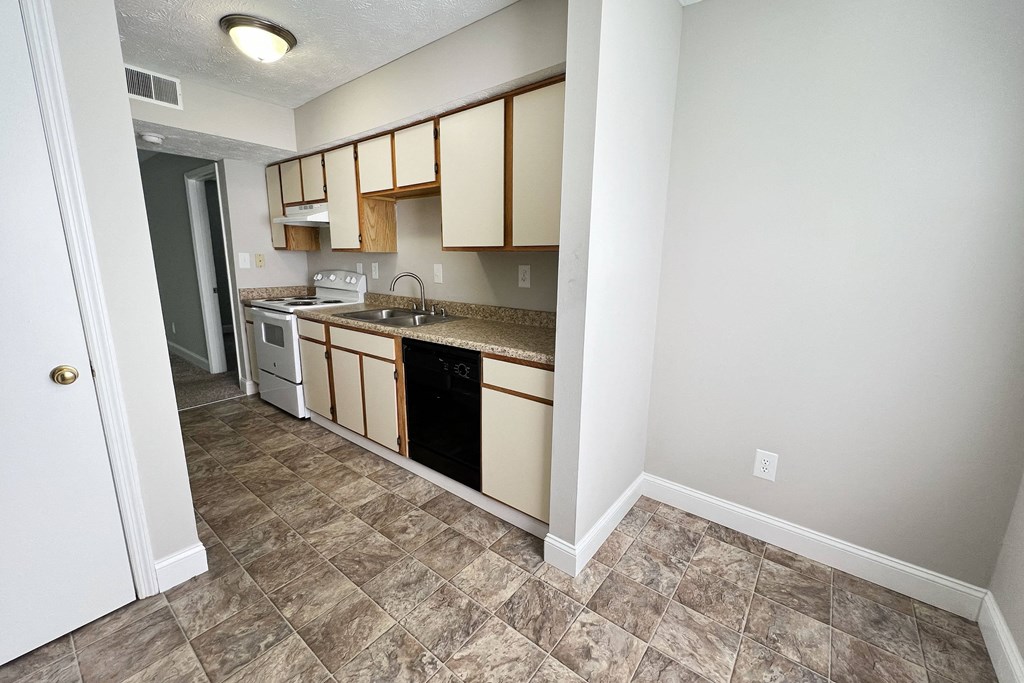 an empty kitchen with a counter top and a sink at 450 on Keeneland Apartments, Richmond, Kentucky