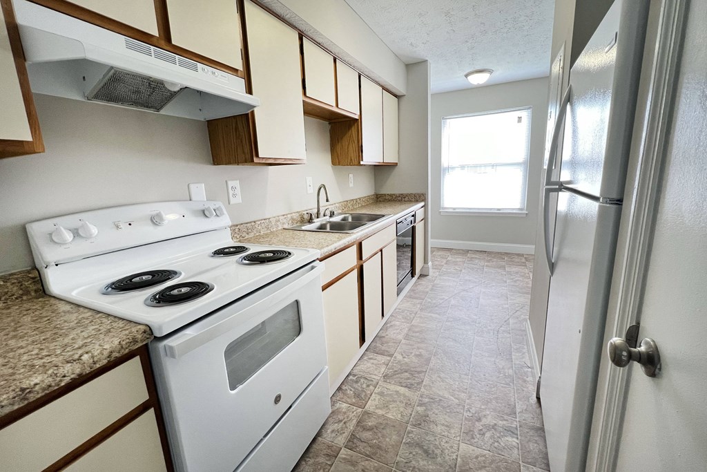an empty kitchen with white appliances and granite counter tops at 450 on Keeneland Apartments, Richmond