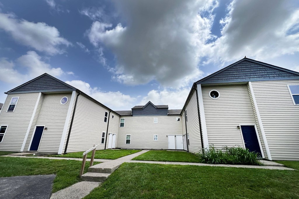 a row of houses with white siding and grass at 450 on Keeneland Apartments, Kentucky, 40475