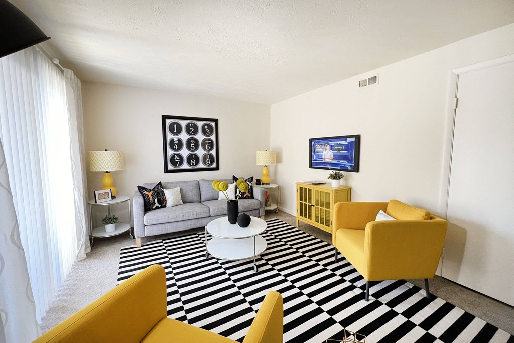 a living room with yellow furniture and a black and white rug at Miamisburg by the Mall, Ohio