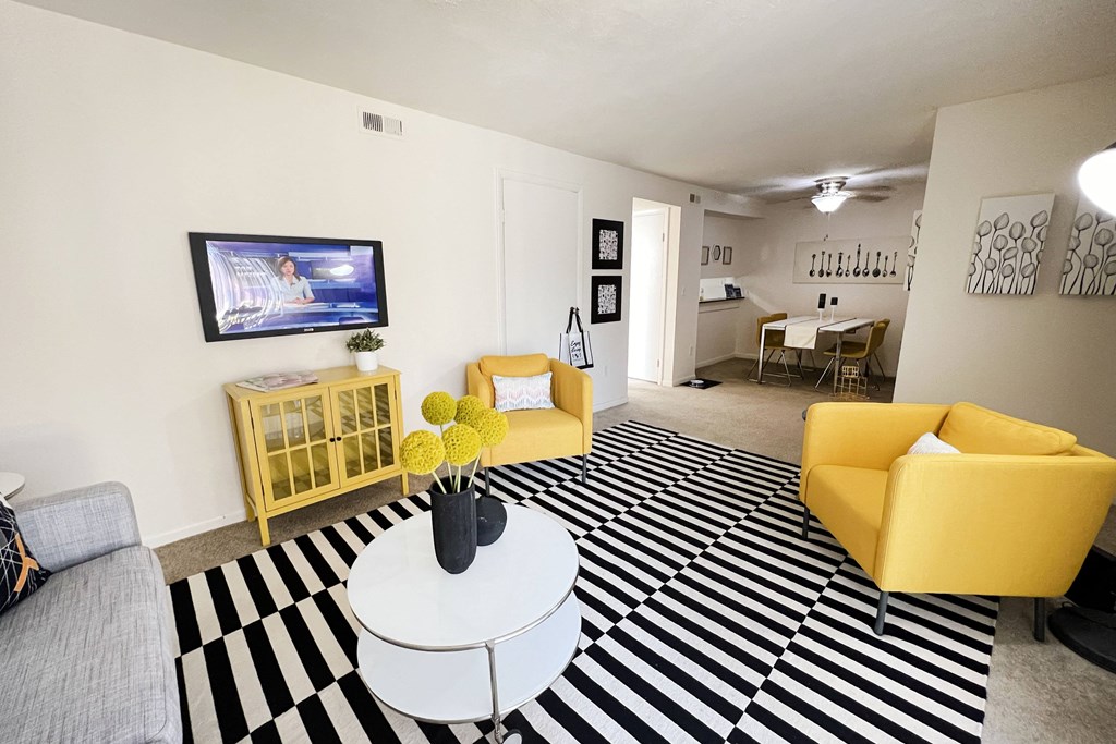 a living room with yellow furniture and a black and white rug at Miamisburg by the Mall, Miamisburg