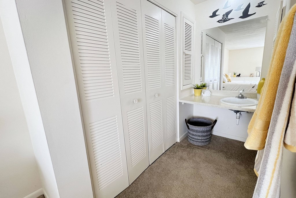 a bathroom with white cabinets and a sink and a mirror at Miamisburg by the Mall, Miamisburg