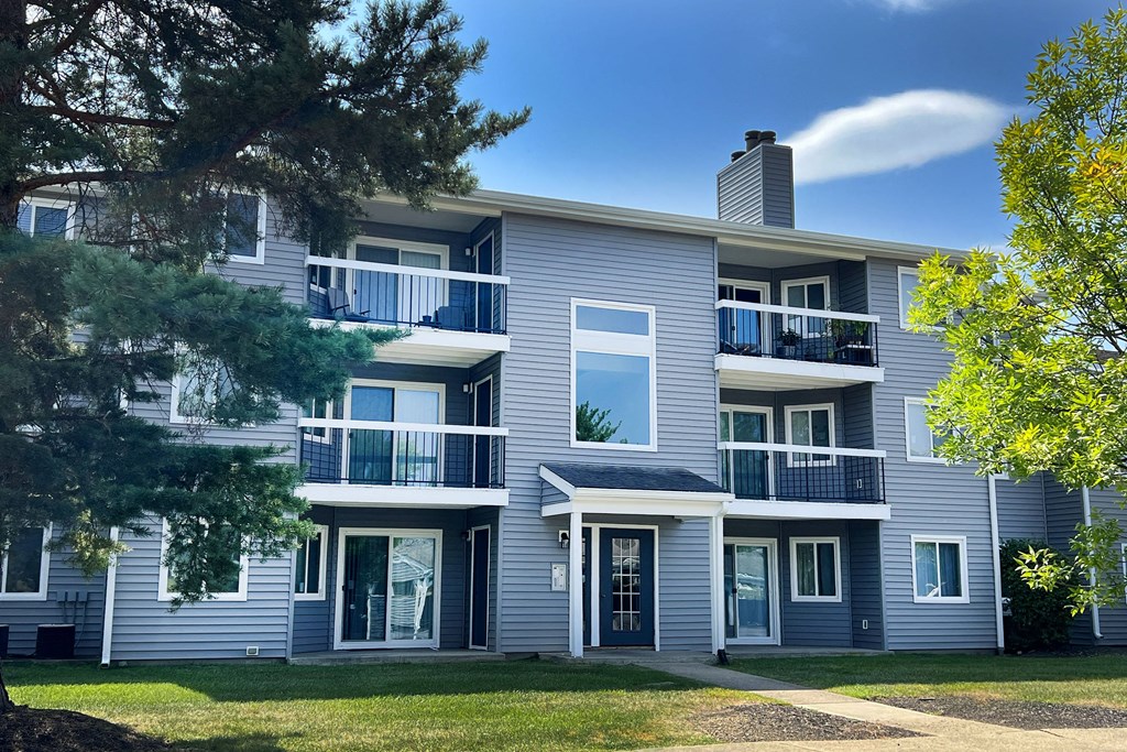 a gray apartment building with a lawn and trees at Deercross Apartments, Cincinnati, OH 45236