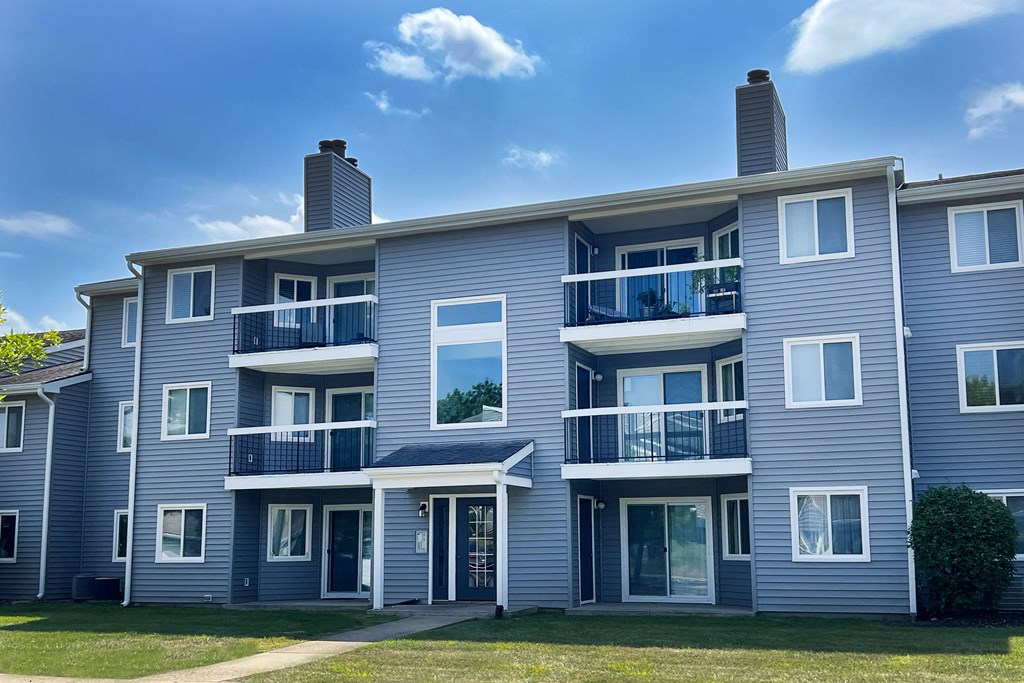 a blue apartment building with balconies on a sunny day at Deercross Apartments, Cincinnati, Ohio