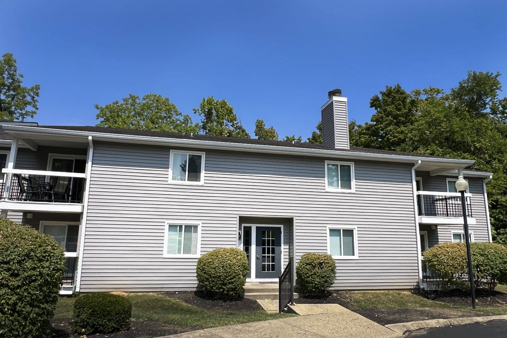 a white house with a blue sky behind it at Deercross Apartments, Cincinnati, OH 45236