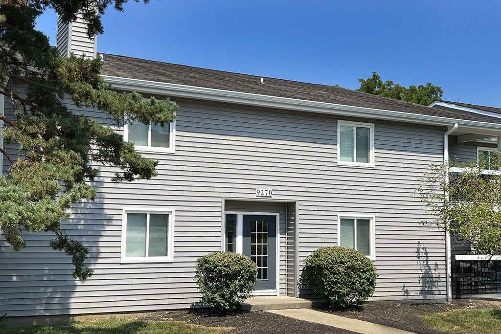 a white house with a tree in front of it at Deercross Apartments, Cincinnati, OH