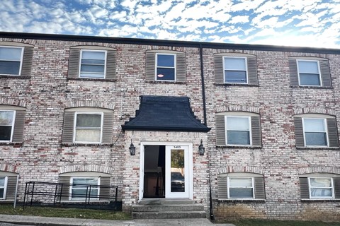 the front of a brick building with a white door