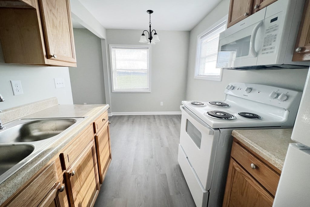a kitchen with white appliances and wooden cabinets