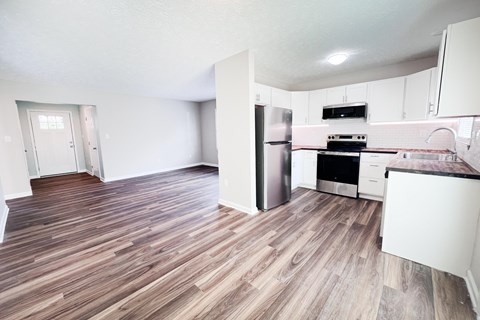 A kitchen with a refrigerator, oven, and stove top.