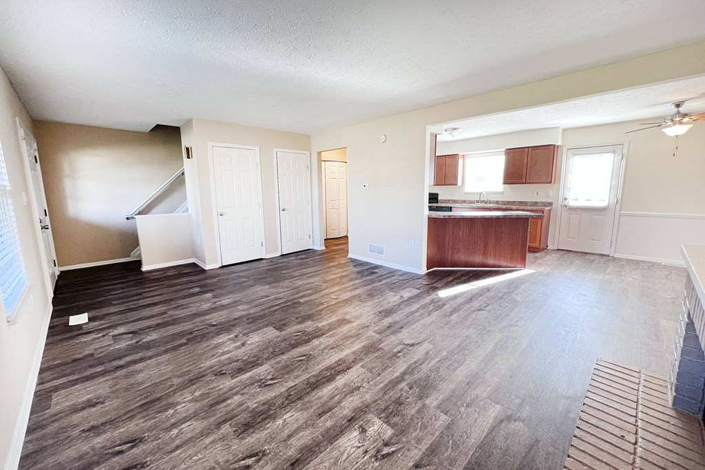 A room with wooden flooring and white walls.