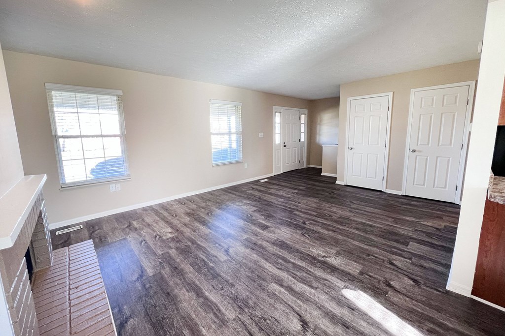A room with wood flooring and white walls.