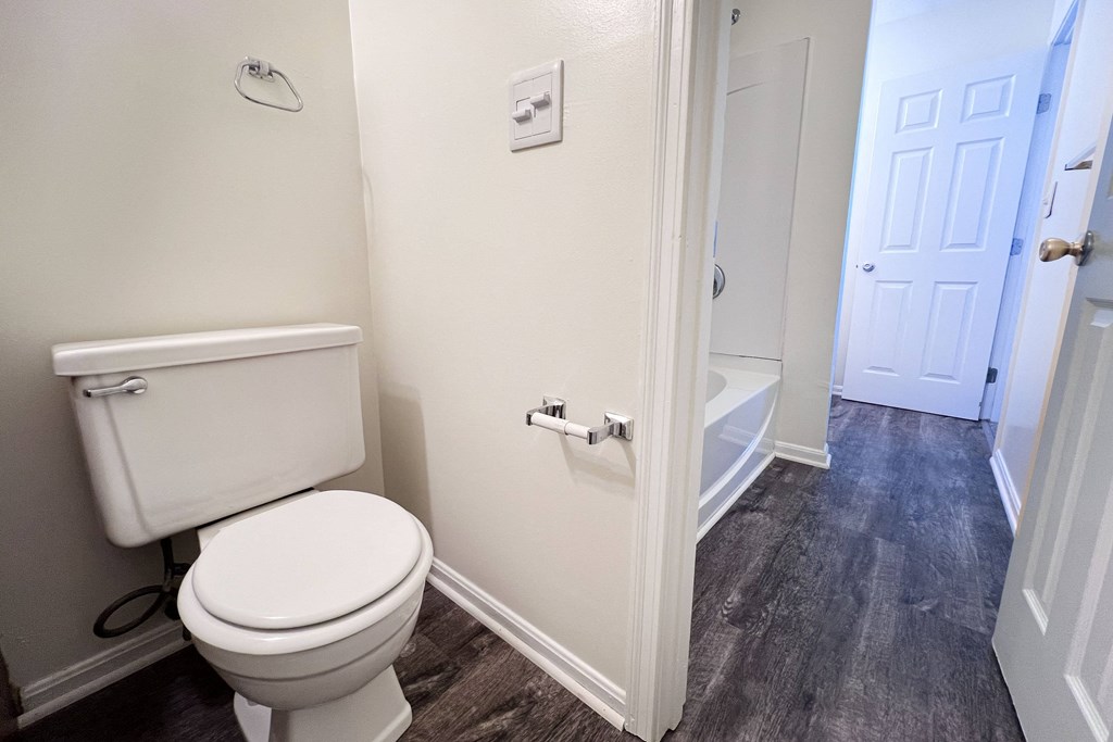 A white toilet in a small bathroom with a white door.