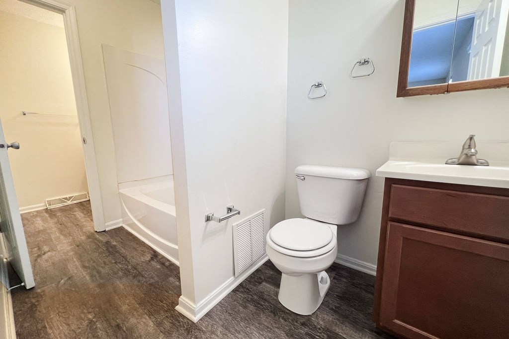 A white toilet sits next to a sink in a bathroom.