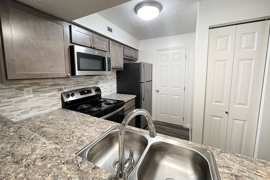 a kitchen with stainless steel appliances and granite counter tops at Deercross Apartments, Ohio