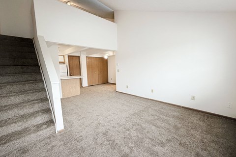 A room with a staircase and carpeted floor.
