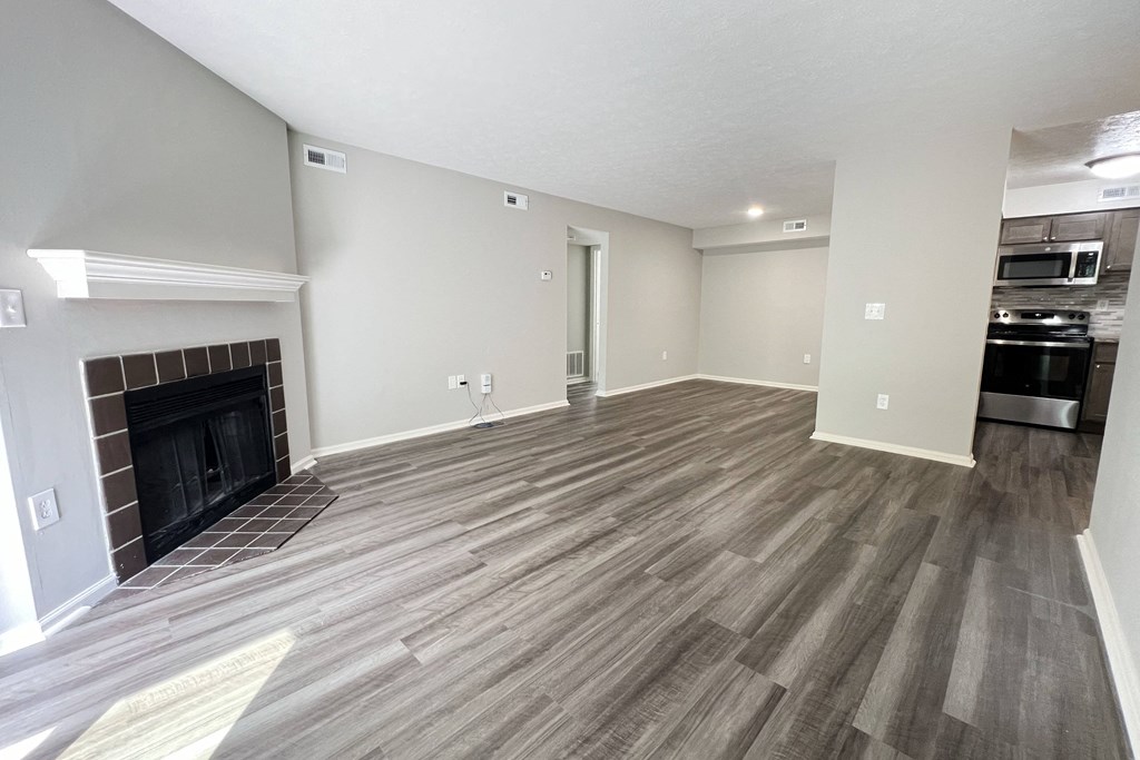 a living room with a fireplace and wooden floors at Deercross Apartments, Cincinnati, OH 45236