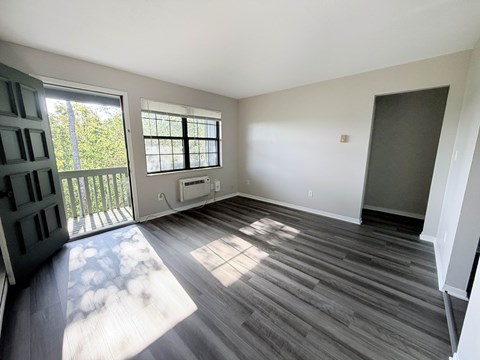A room with a sliding glass door leading to a balcony.
