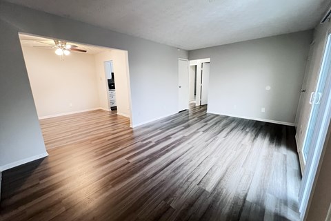 A room with wooden flooring and white walls.
