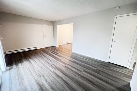 A room with wooden flooring and white walls.