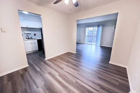 A room with a ceiling fan and wooden flooring.
