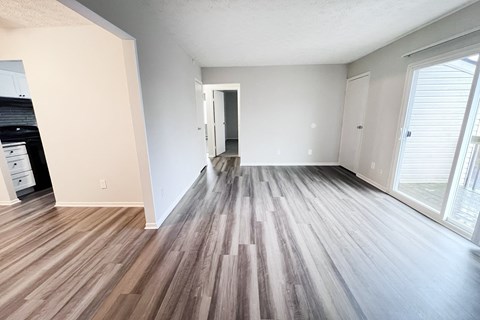 A room with wooden flooring and white walls.