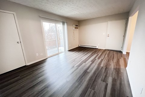 A room with wooden flooring and white walls.