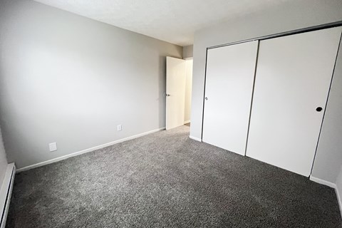 A room with a carpeted floor and a white door.