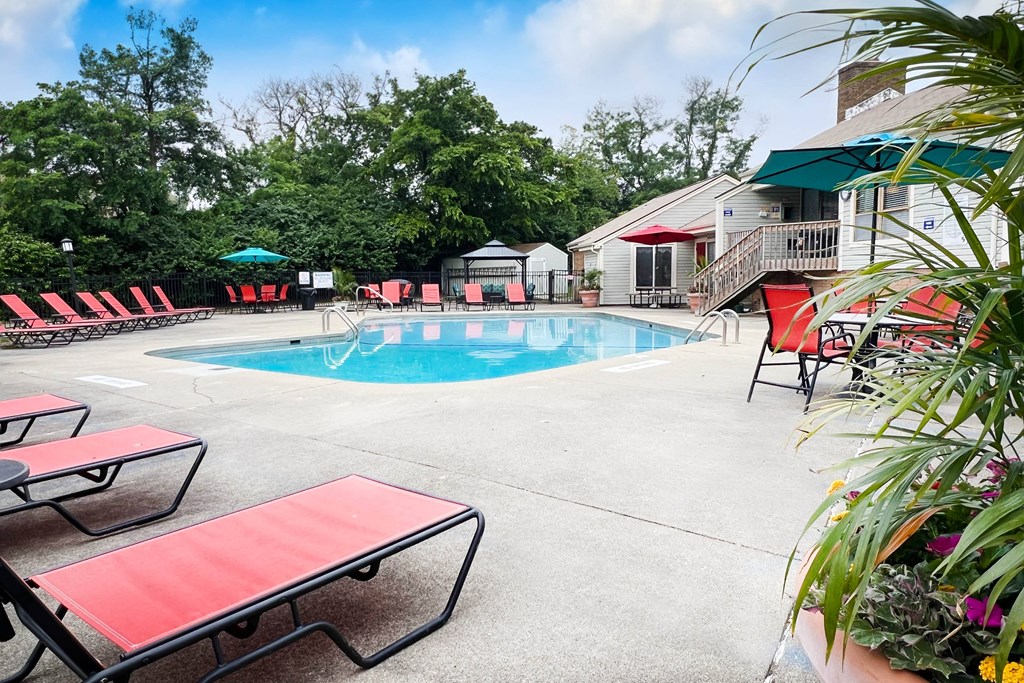 a swimming pool with red chaise lounge chairs and umbrellas  at Hunter's Creek Apartments, Ohio, 45242