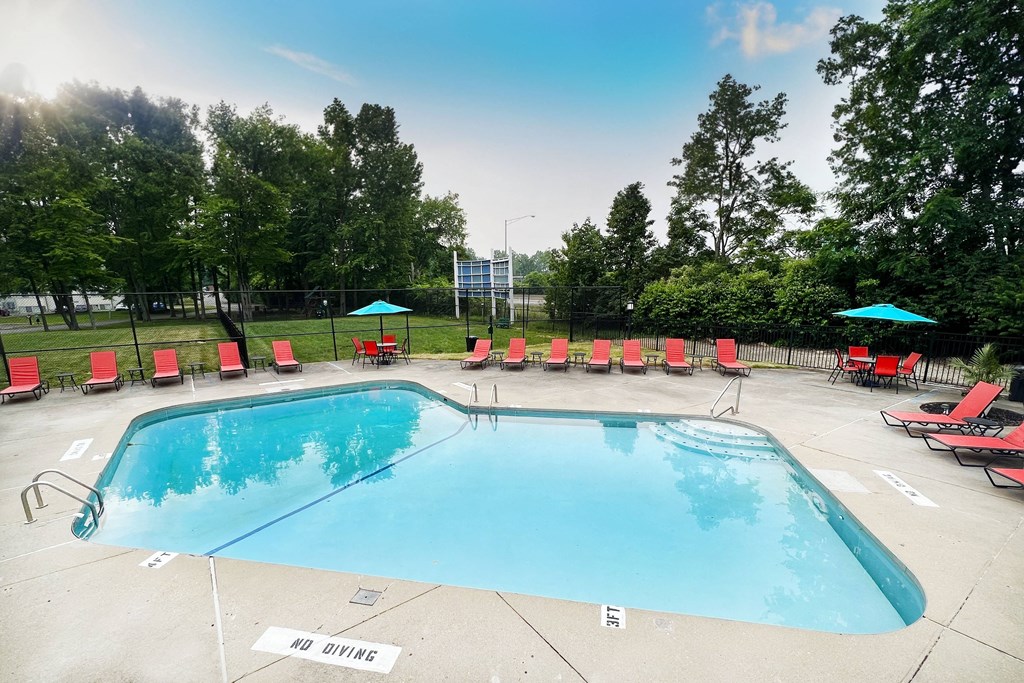 a swimming pool with red lounge chairs and umbrellas  at Hunter's Creek Apartments, Cincinnati, 45242