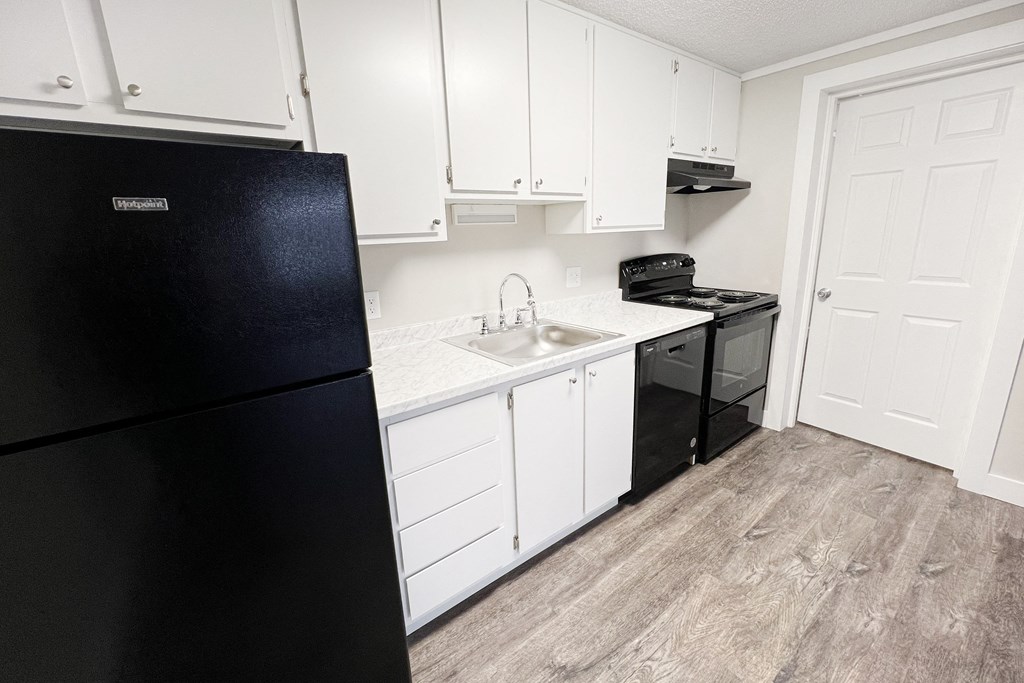 a kitchen with white cabinets and a black refrigerator  at Wentworth Estates Apartments, Florence, Kentucky