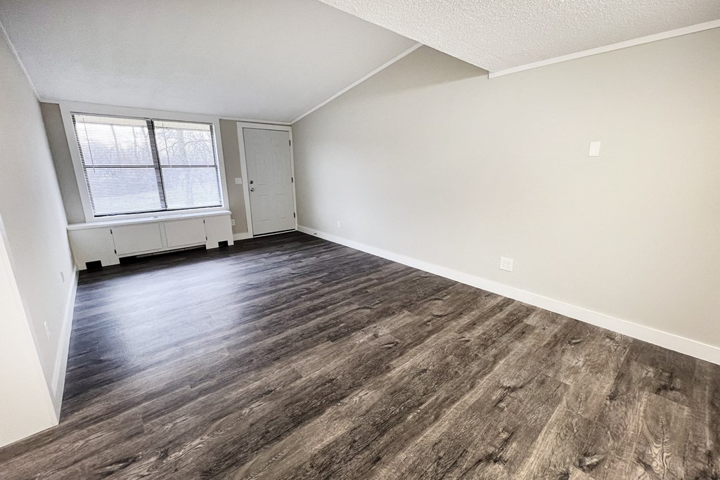 an empty living room with wood flooring and a window  at Wentworth Estates Apartments, Florence, Kentucky