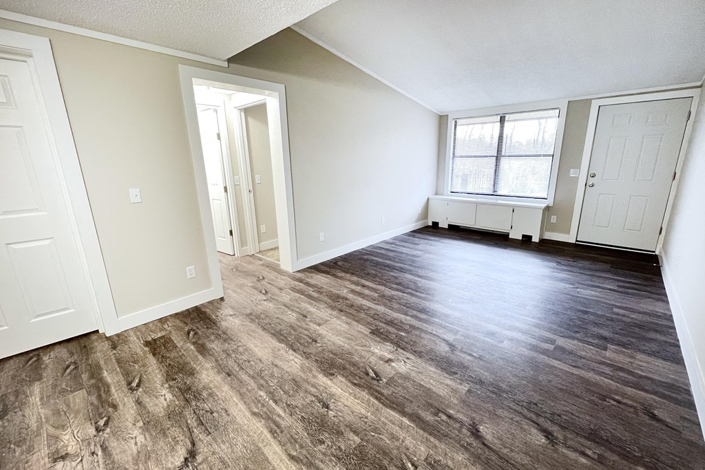 an empty living room with white walls and wood floors at Wentworth Estates Apartments, Florence, KY