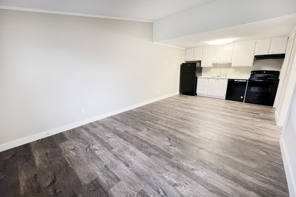 an empty living room with wood flooring and a kitchen  at Wentworth Estates Apartments, Florence, Kentucky