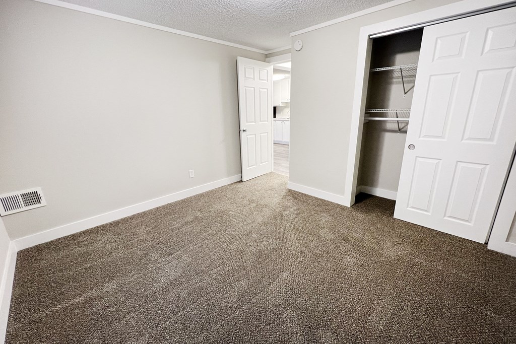an empty room with carpet and a closet  at Wentworth Estates Apartments, Florence, Kentucky
