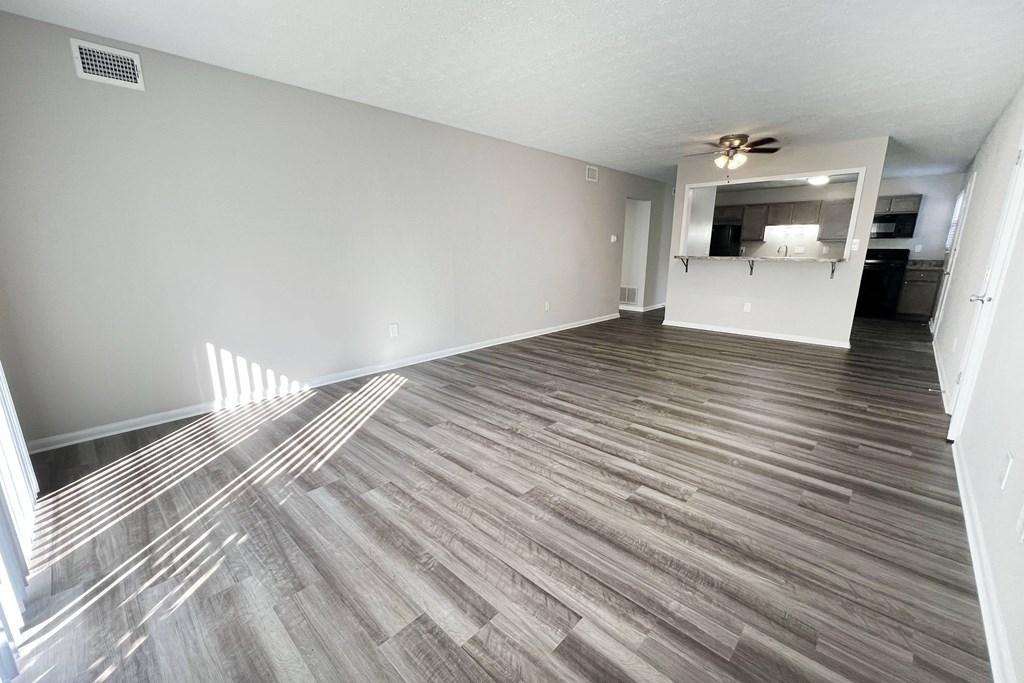 A room with wooden flooring and a ceiling fan.
