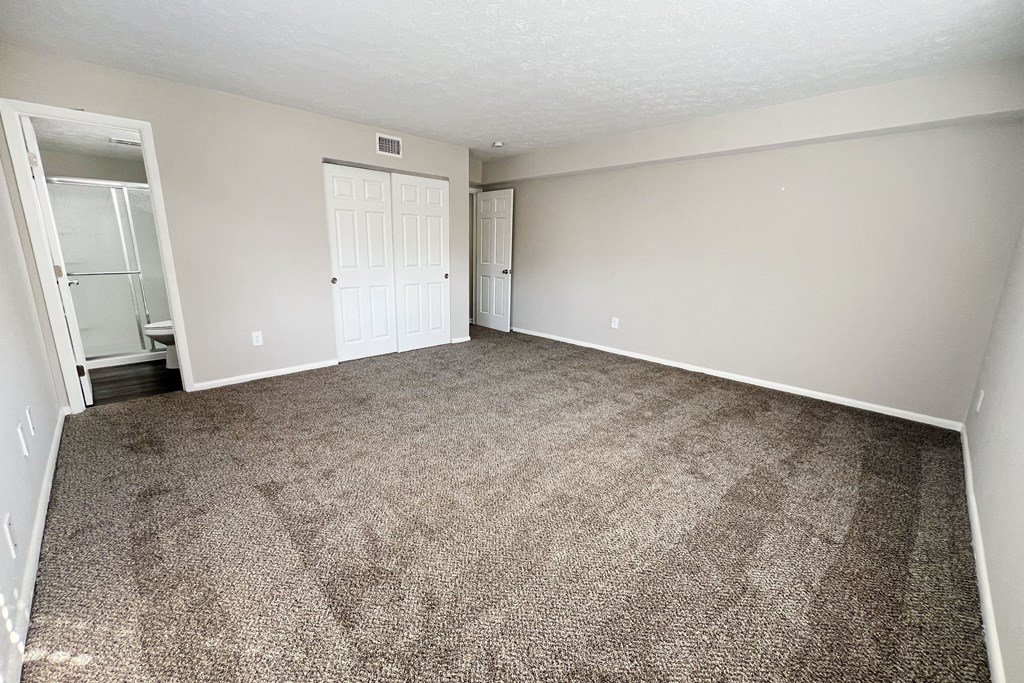 an empty living room with carpeting and white walls at Revere Village Apartments, Centerville