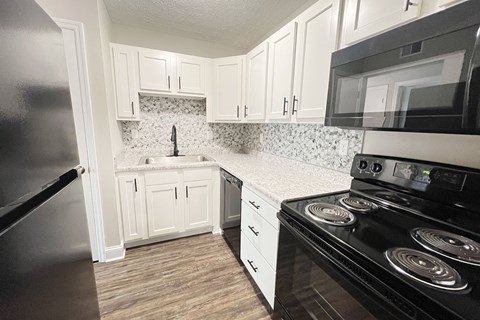 a kitchen with black appliances and white cabinets