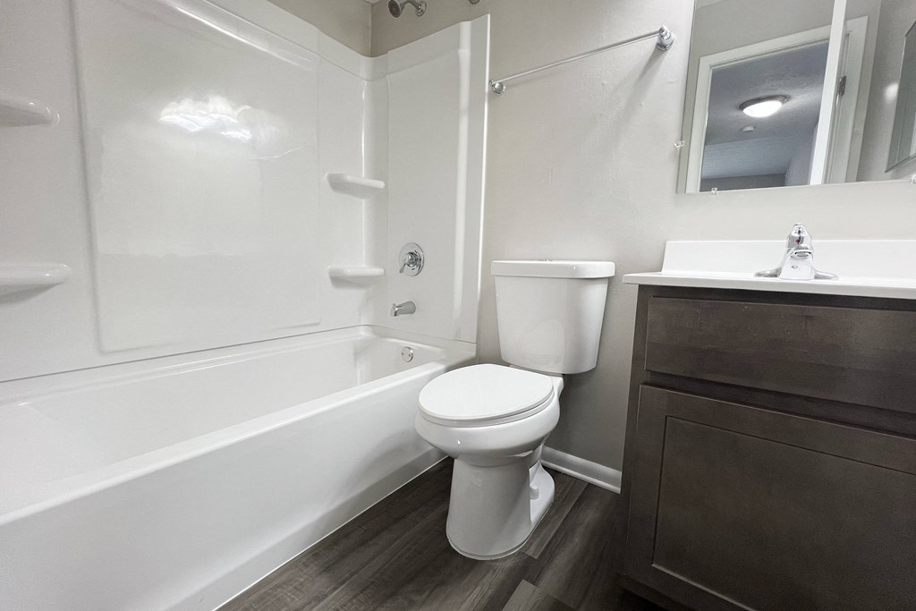 a bathroom with a toilet and a tub and a sink at Revere Village Apartments, Centerville