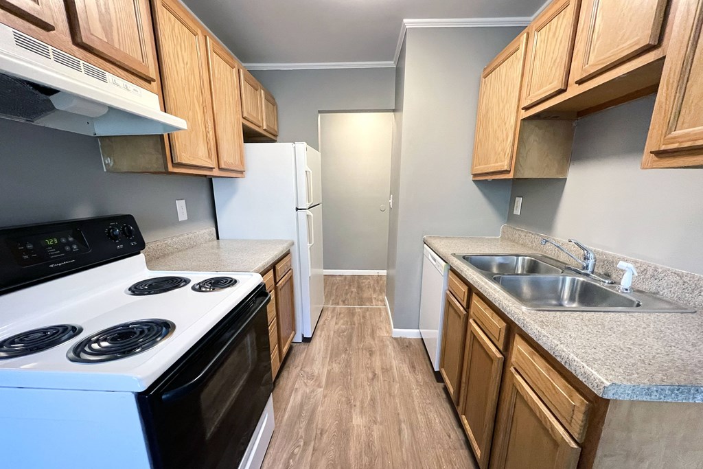 A kitchen with a white stove and a white refrigerator.