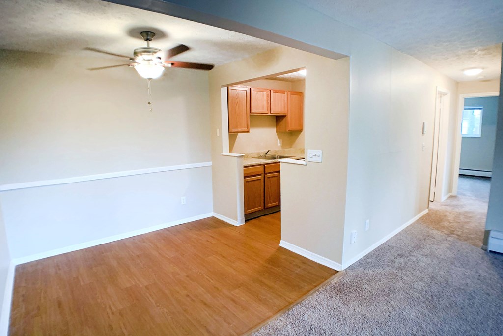 A room with a ceiling fan and wooden flooring.