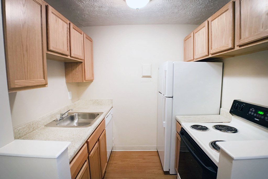 A kitchen with wooden cabinets and white appliances.