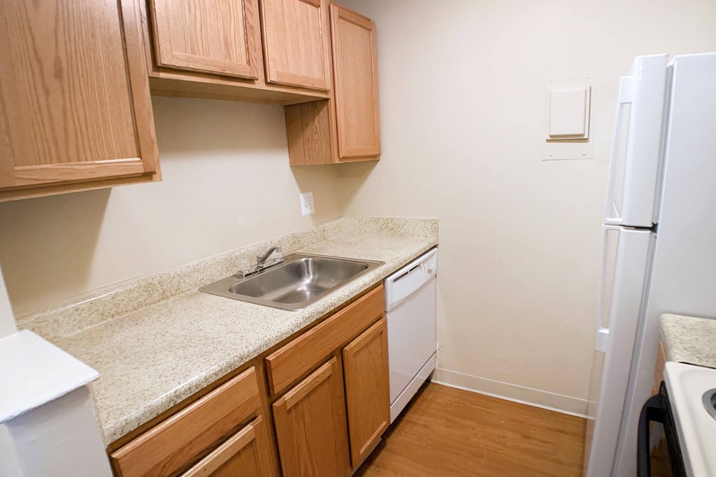 A kitchen with wooden cabinets and a white refrigerator.
