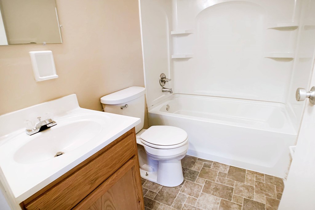 A white toilet sits next to a sink in a bathroom.