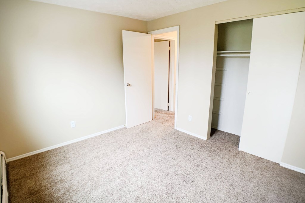 A room with a carpeted floor and a doorway leading to another room.