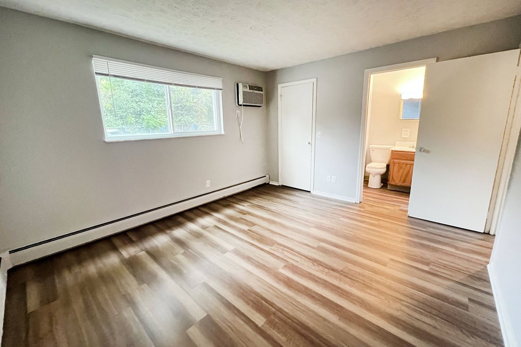 A room with wooden flooring and a window.