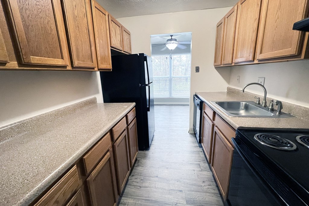 A kitchen with wooden cabinets and black appliances.